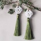 Close-up of white Mizuhiki Awaji Knot earrings featuring a tassel, handmade by itookasi for eternal bonds.