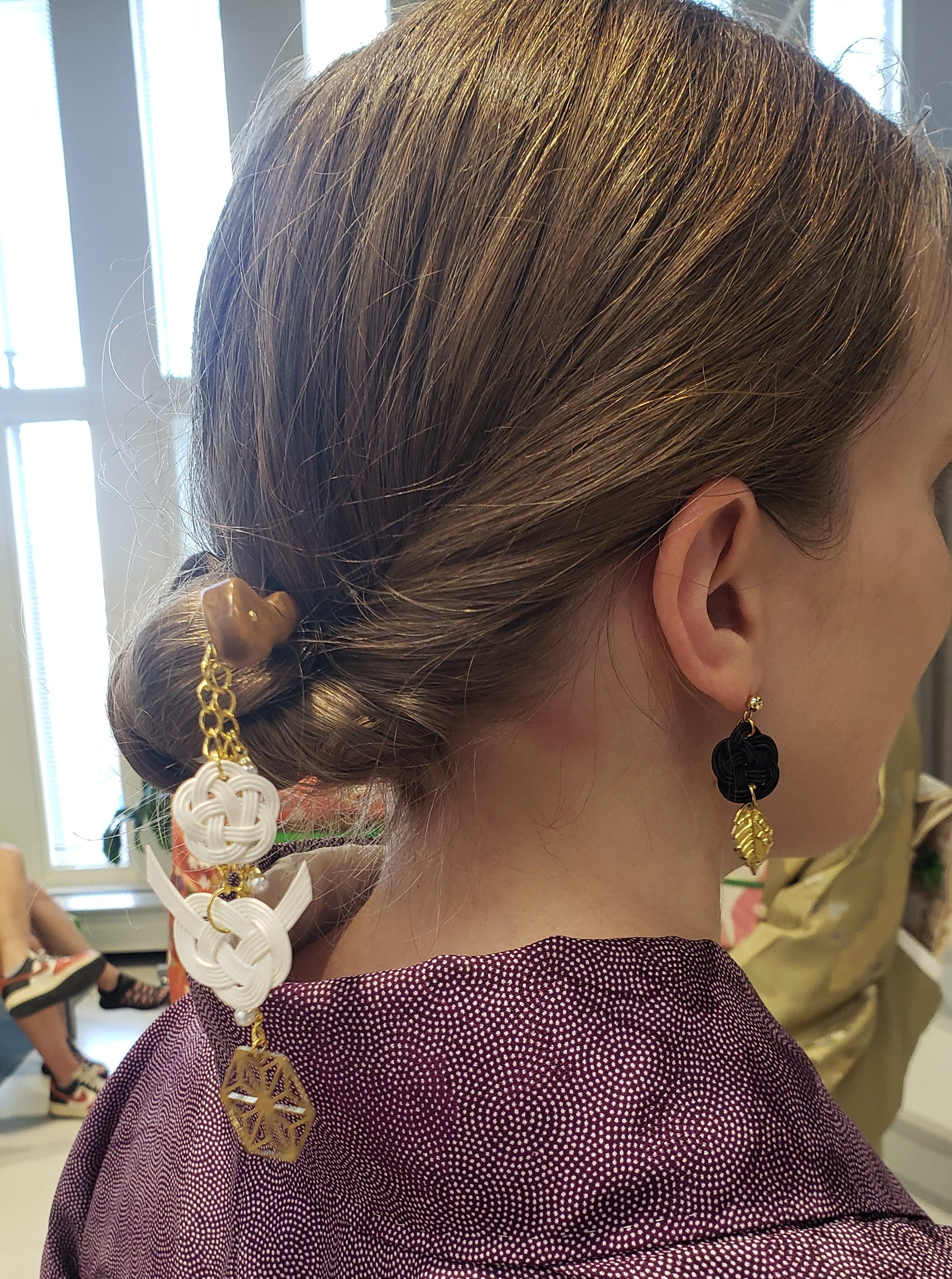 Cose-up of a woman in a kimono wearing a mizuhiki kanzashi and plum blossom knot earrings, handmade by itookasi. 