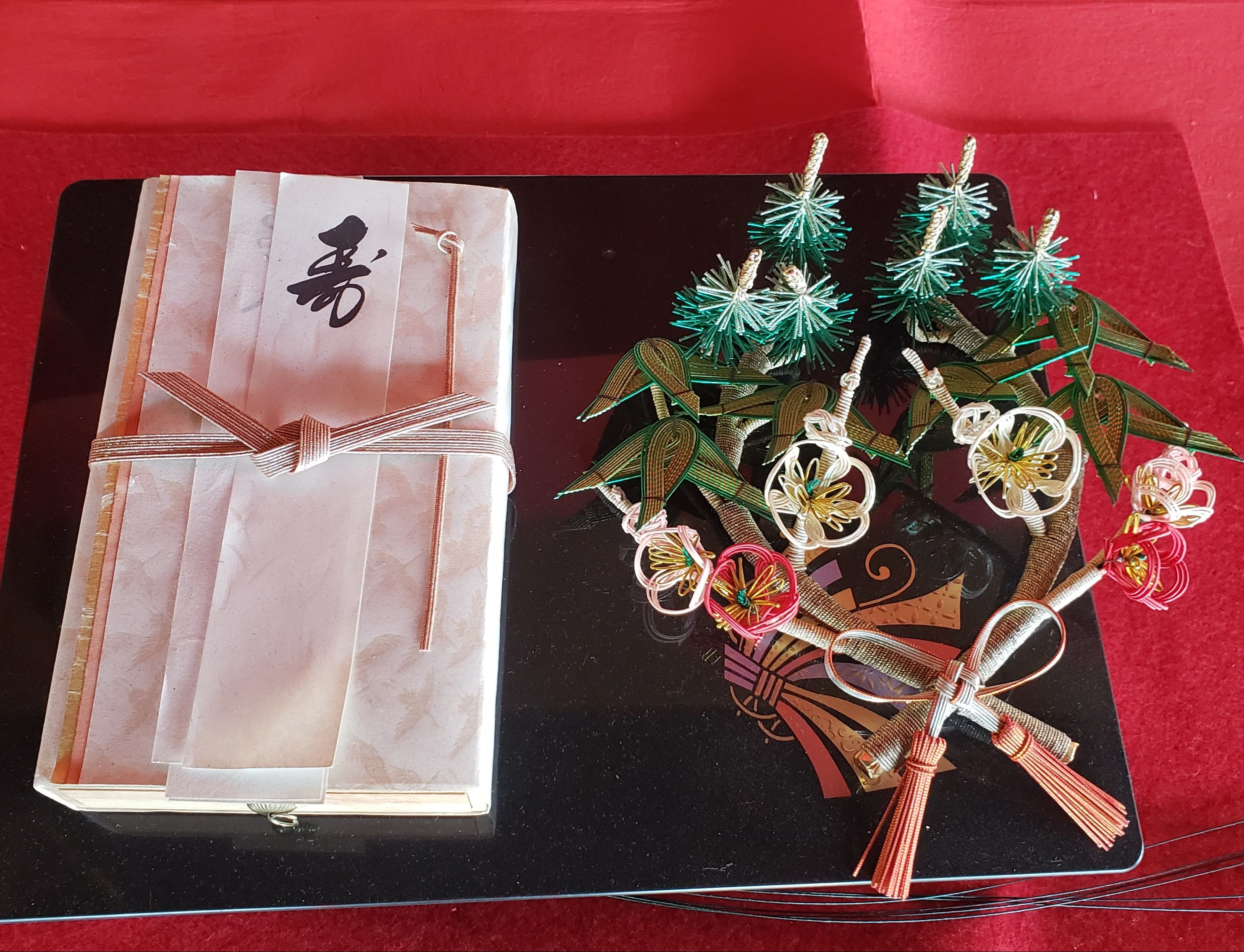 Close-up of a congratulatory envelope decorated with mizuhiki and an object adorned with pine, bamboo, and plum knots mizuhiki.