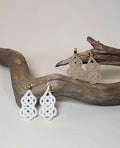 Close-up of white and beige gourd-shaped Mizuhiki awaji knot earrings handmade by Itookasi. A blend of Japanese craft and Finnish nature symbolizing strong bonds.