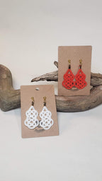 Close-up of white and orange gourd-shaped Mizuhiki awaji knot earrings handmade by Itookasi. A blend of Japanese craft and Finnish nature symbolizing strong bonds.