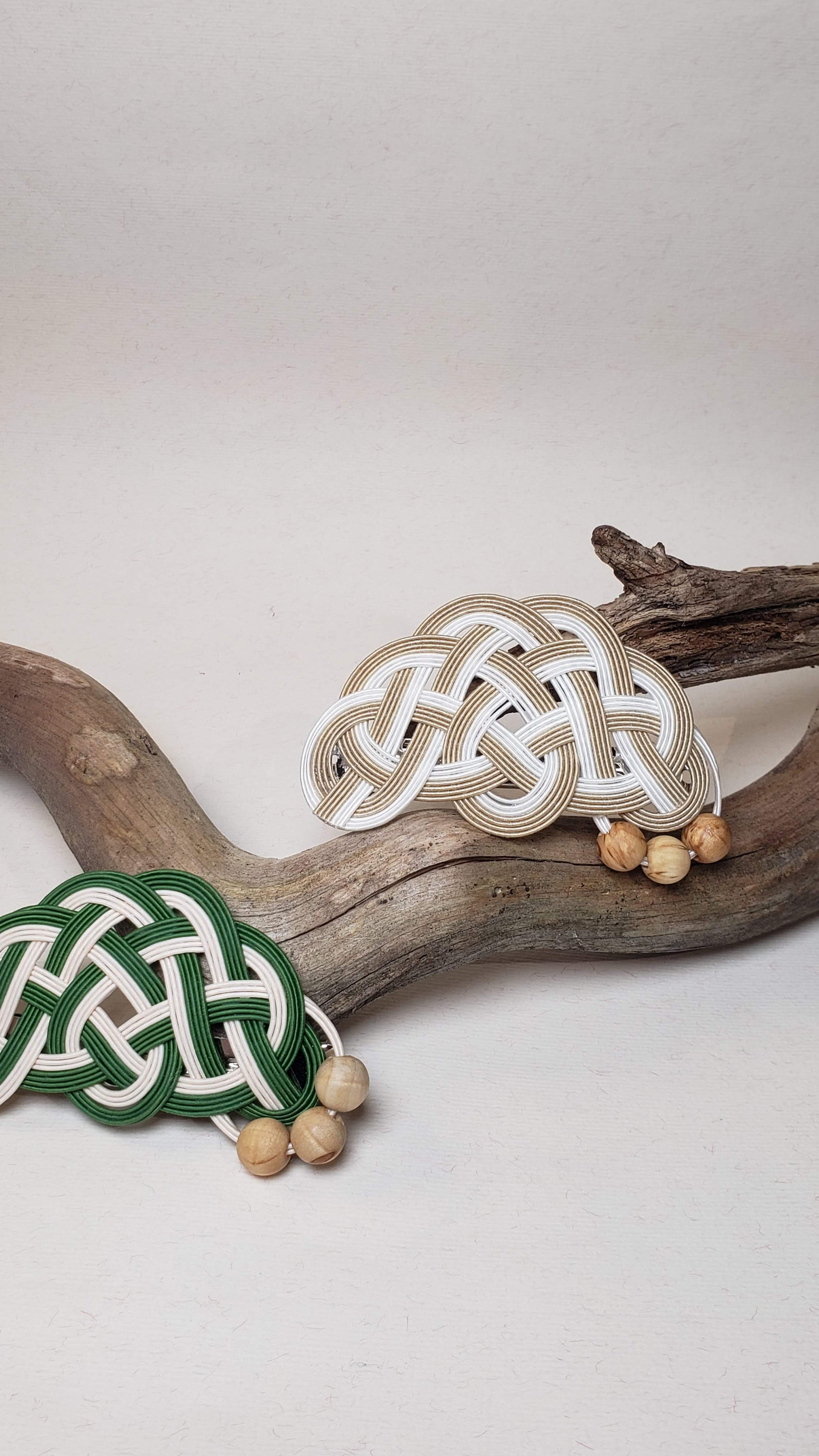 Close-up of a beige and green Mizuhiki pine knot hair barrettes with Finnish wood beads, handmade by Itookasi. A blend of Japanese craft and Finnish nature, symbolizing longevity and happiness.