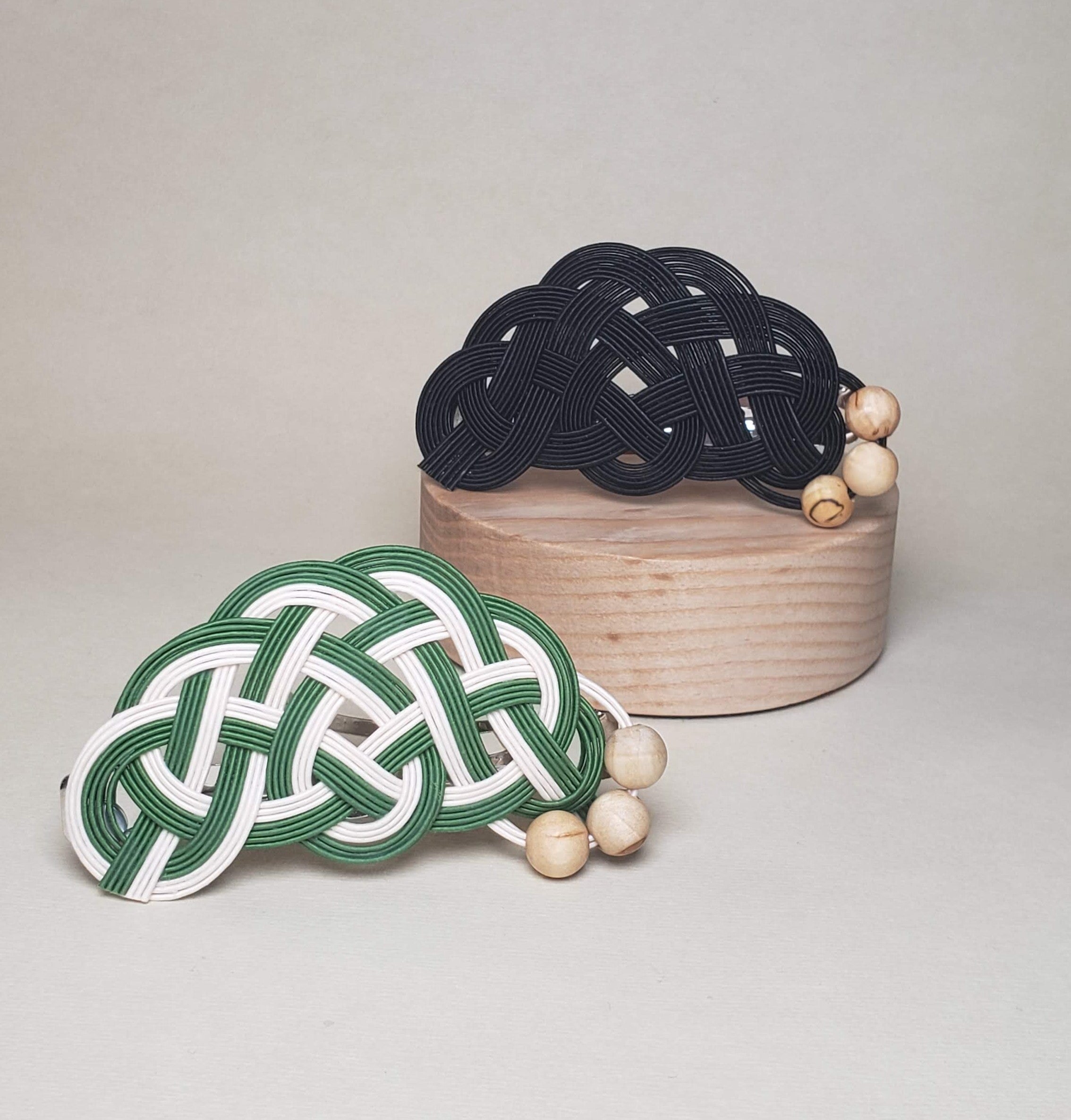 Close-up of a pair of Mizuhiki pine knot hair barrettes in different colors with Finnish wood beads, handmade by Itookasi. A blend of Japanese craft and Finnish nature, symbolizing longevity and happiness.