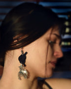 Close-up of black Mizuhiki Awaji knot earrings featuring a delicate goldfish charm, worn by a model, handmade by itookasi. 
