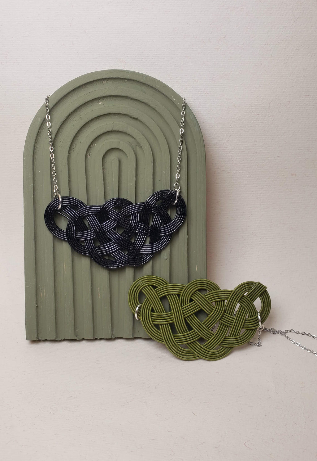 Close-up of a black and green Mizuhiki pine knot necklace, handmade by Itookasi. The pine knot (Matsu-musubi) symbolises longevity and happiness.