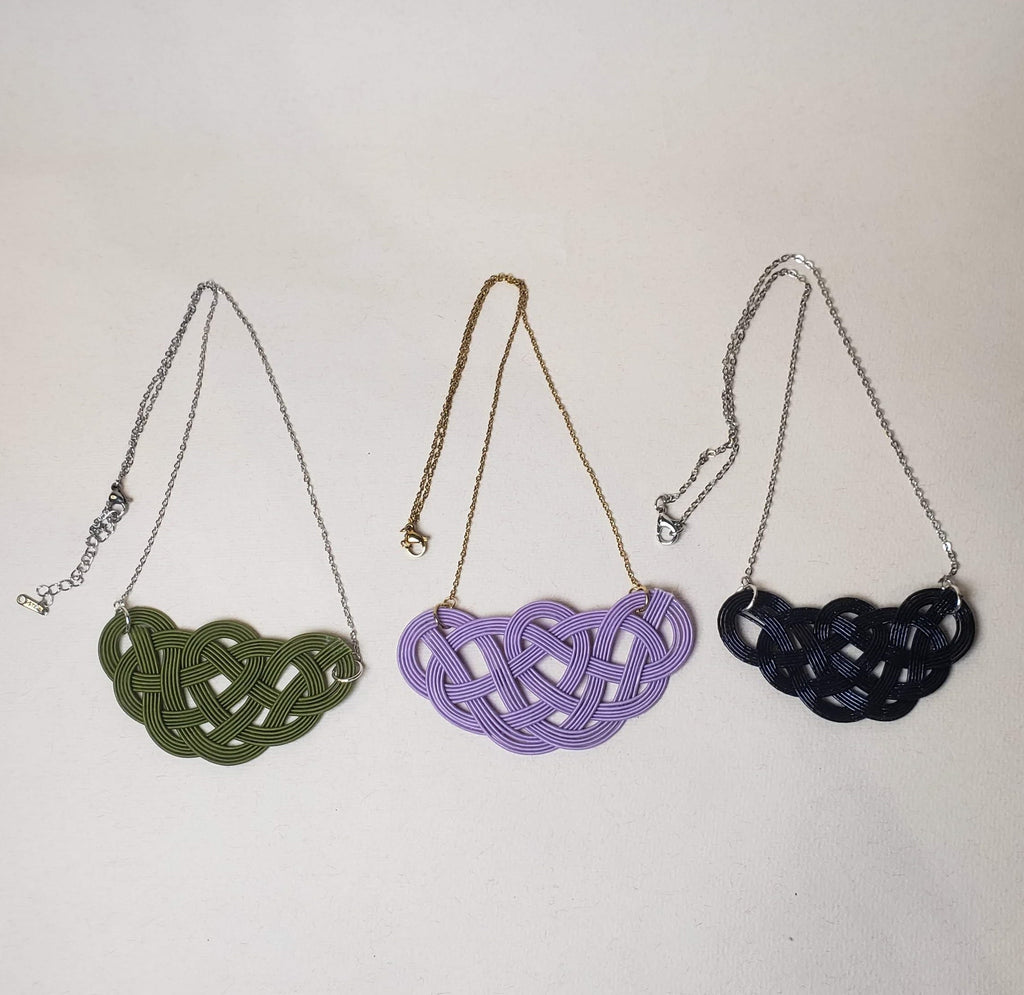 Close-up of a black, green and purple Mizuhiki pine knot necklace, handmade by Itookasi. The pine knot (Matsu-musubi) symbolises longevity and happiness.