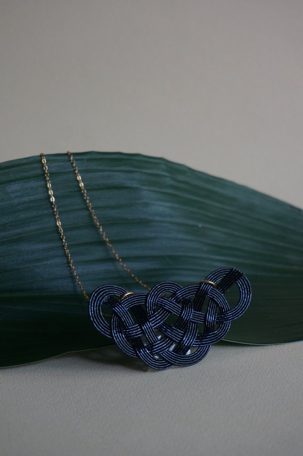 Close-up of a black Mizuhiki pine knot necklace, handmade by Itookasi. The pine knot (Matsu-musubi) symbolises longevity and happiness.