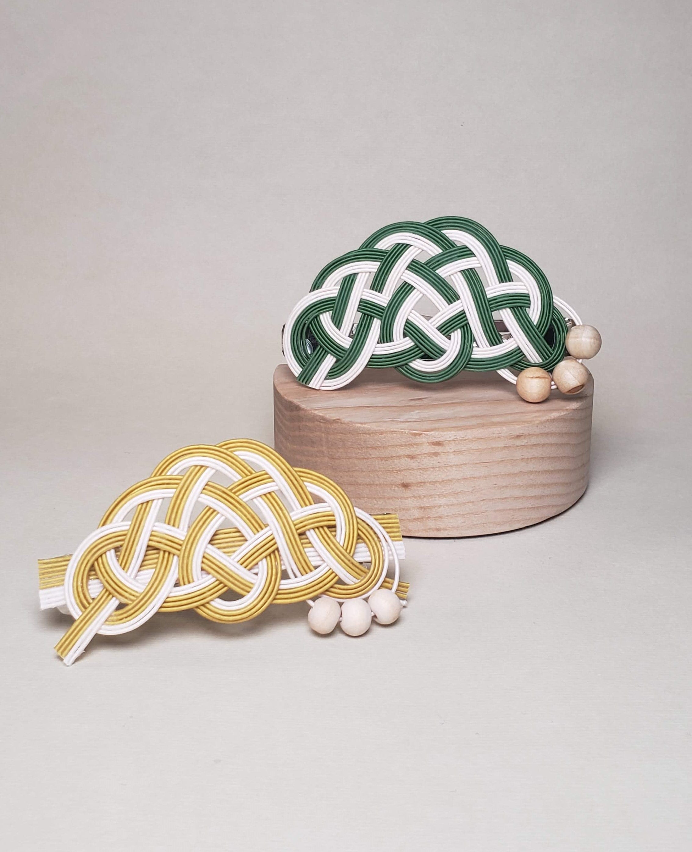 Close-up of a pair of Mizuhiki pine knot hair barrettes in different colors with Finnish wood beads, handmade by Itookasi. A blend of Japanese craft and Finnish nature, symbolizing longevity and happiness.