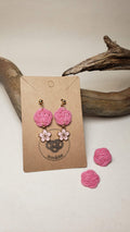 Close-up of earrings with pink plum blossom knot and cherry blossom charms, handmade by itookasi for eternal bonds.